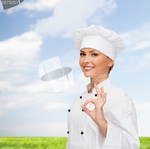 Image of smiling female chef showing ok hand sign