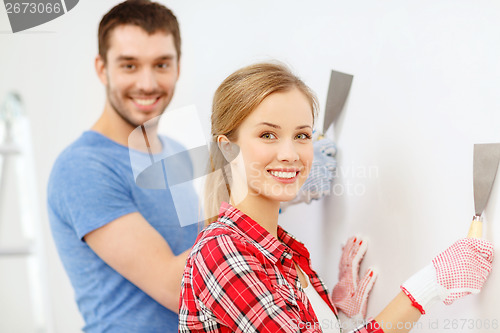 Image of smiling couple doing renovations at home