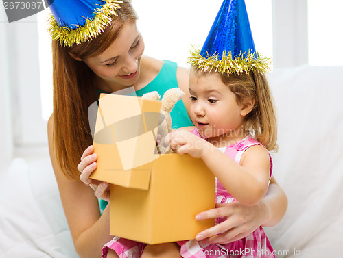 Image of mother and daughter in blue hats with favor horns