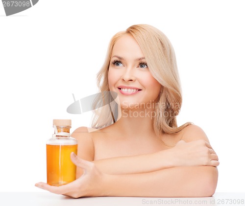 Image of happy woman with oil bottle