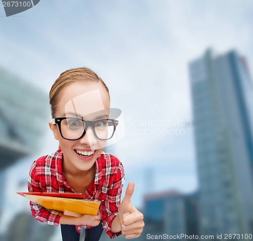 Image of student in glasses with folders showing thumbs up