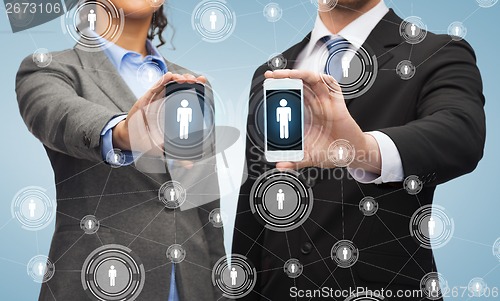 Image of businessman and businesswoman with smartphones
