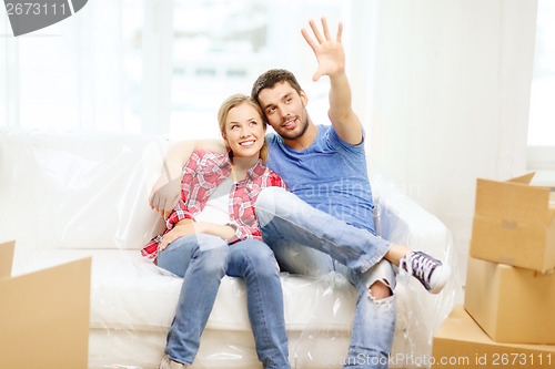 Image of smiling couple relaxing on sofa in new home