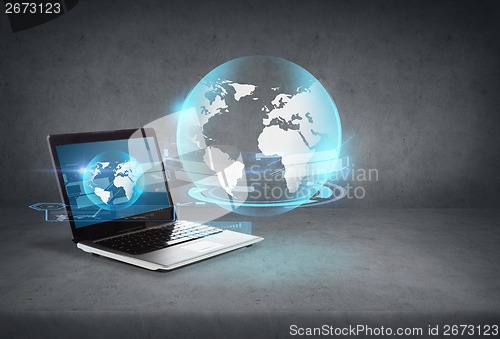 Image of laptop computer with globe hologram on screen