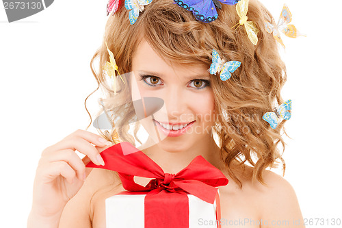 Image of teenager with butterflies in hair opening present