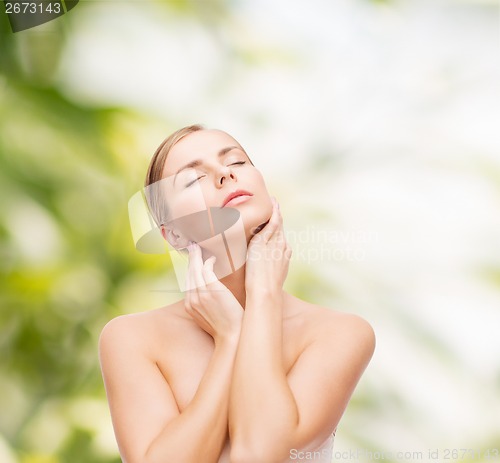 Image of beautiful woman touching her face with closed eyes