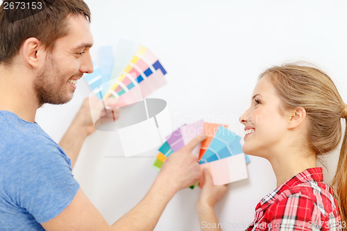 Image of smiling couple looking at color samples at home