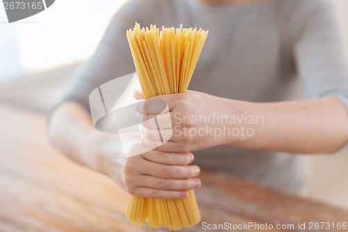 Image of close up of female hands holding spaghetti pasta