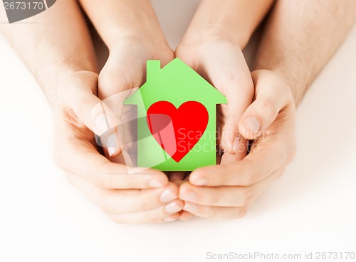 Image of couple hands holding green paper house