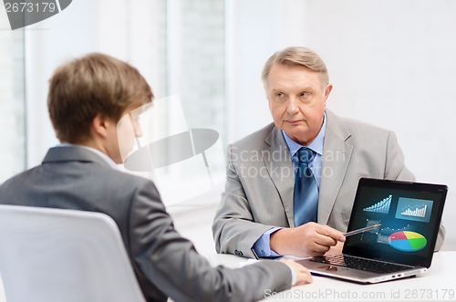 Image of older man and young man with laptop computer