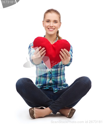 Image of young woman in casual clothes sitting on floor