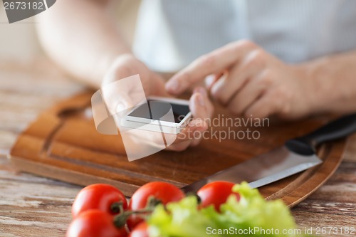 Image of closeup of man pointing finger to smartphone