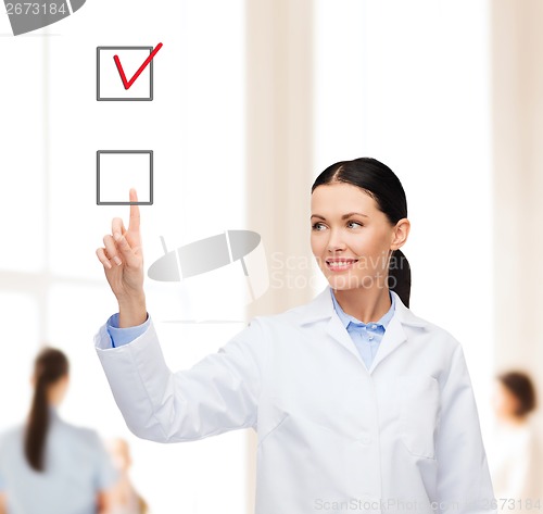 Image of smiling female doctor pointing checkbox