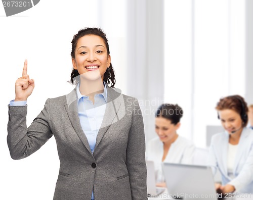 Image of smiling businesswoman with her finger up at office