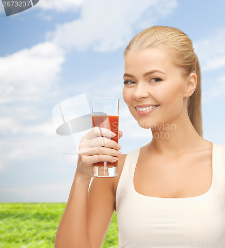 Image of smiling woman holding glass of tomato juice
