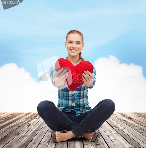 Image of young woman in casual clothes sitting on floor