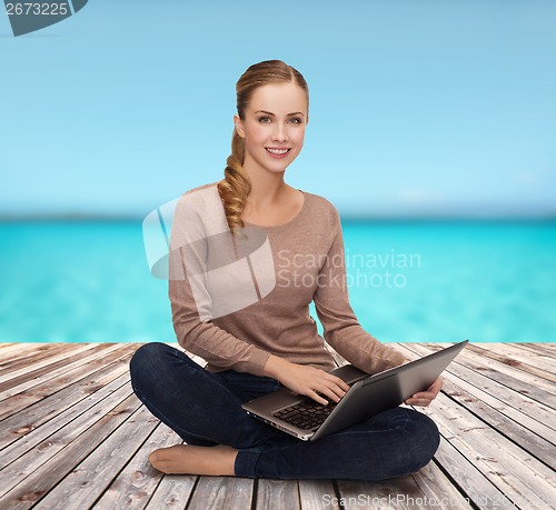 Image of young woman sitting on floor with laptop