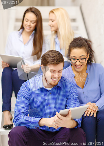 Image of team with tablet pc computer sitting on staircase