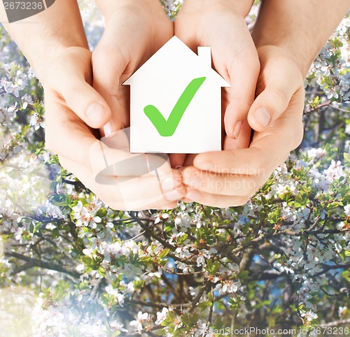 Image of hands holding house with check mark