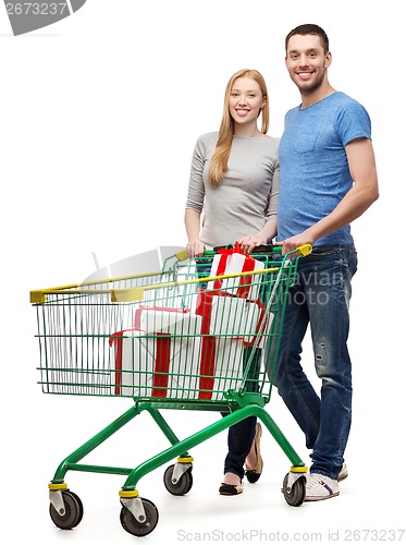 Image of smiling couple with shopping cart and gift boxes