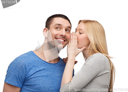 Image of smiling girlfriend telling boyfriend secret