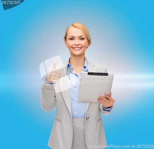 Image of smiling woman with tablet pc showing thumbs up