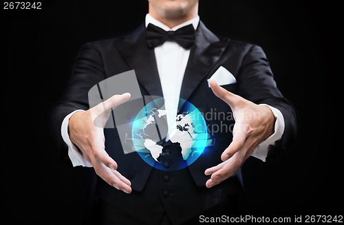 Image of magician in top hat showing globe hologram