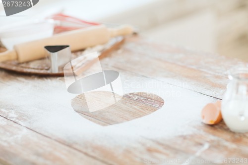 Image of close up of heart of flour on wooden table at home