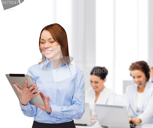 Image of smiling woman looking at tablet pc at office