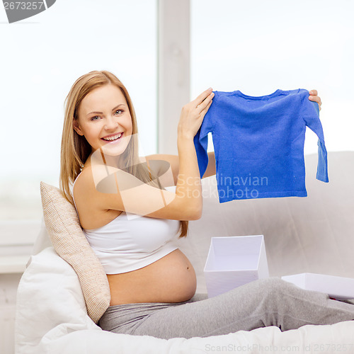 Image of smiling pregnant woman opening gift box