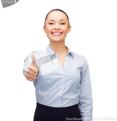 Image of young smiling businesswoman showing thumbs up