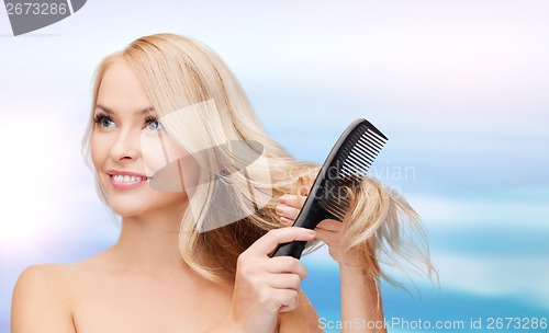 Image of smiling woman with hair brush