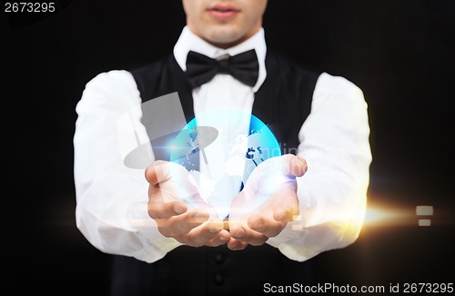 Image of dealer holding globe on palms of his hands