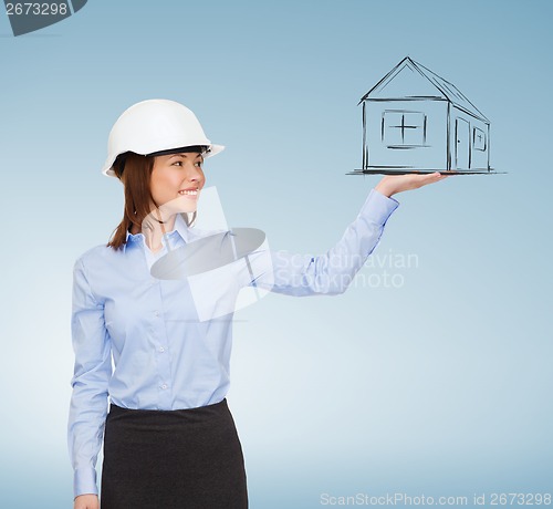 Image of young smiling businesswoman in white helmet