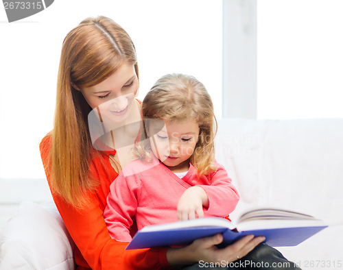 Image of happy mother and daughter with book