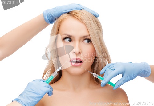 Image of woman face and beautician hands with syringes