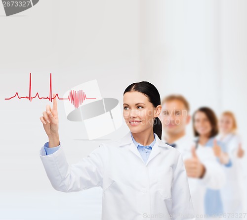 Image of smiling female doctor pointing to cardiogram