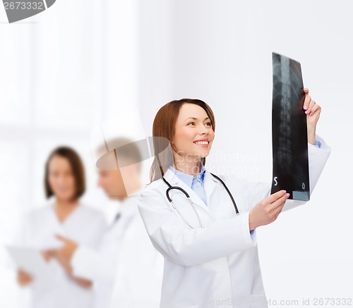 Image of smiling female doctor looking at x-ray