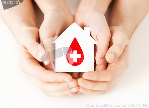 Image of hands holding house with donor sign