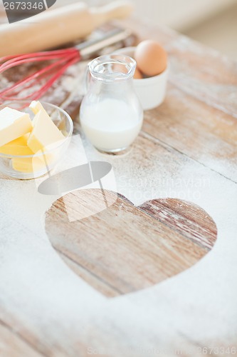 Image of close up of heart of flour on wooden table at home