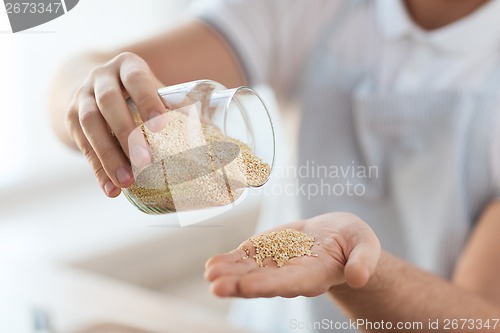 Image of close up of male emptying jar with quinoa