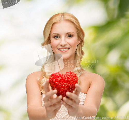 Image of smiling woman giving small red heart