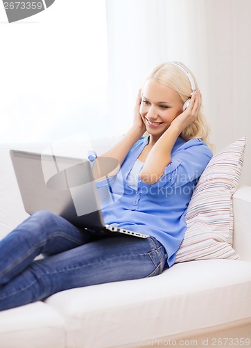 Image of woman with laptop computer and headphones at home