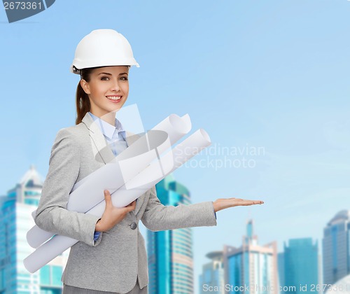 Image of smiling architect in white helmet with blueprints