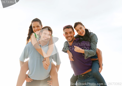 Image of group of smiling people having fun on the beach