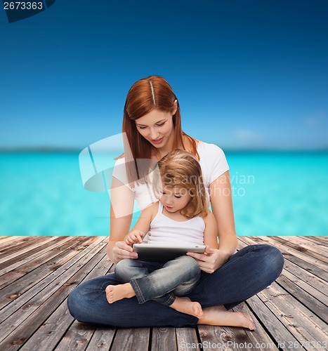 Image of happy mother with little girl and tablet pc