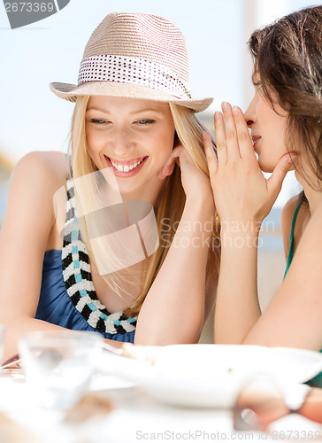 Image of girls gossiping in cafe on the beach