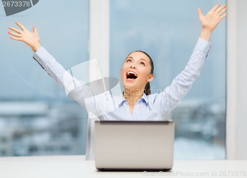 Image of screaming businesswoman with laptop in office