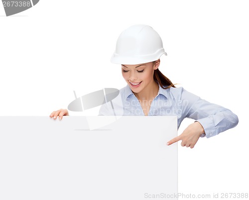 Image of businesswoman in helmet pointing finger to board