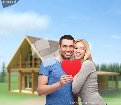 Image of smiling couple holding big red heart